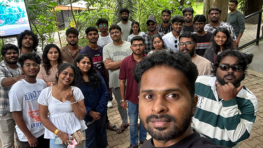 Group selfie of the team outdoors among greenery during a company outing